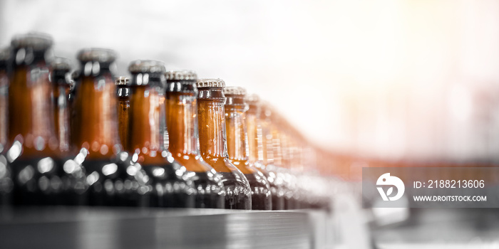 Beer bottles on conveyor production line belt. Brewery factory manufacturing plant