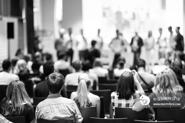 Young business team receiving award prize at best business project competition event. Business and entrepreneurship award ceremony theme. Black and white image.