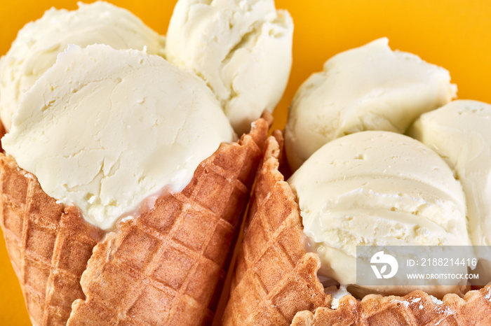 ice cream balls in a Waffle Cone on a yellow Background. Vanilla ice cream in a waffle cone.