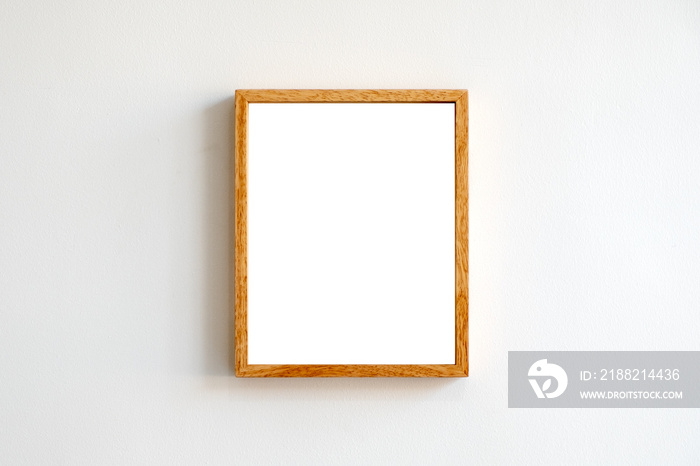 A blank wooden picture frame on white wall background