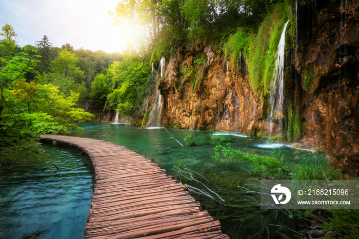 Beautiful wooden path trail for nature trekking with lakes and waterfall landscape in Plitvice Lakes National Park, UNESCO natural world heritage and famous travel destination of Croatia.