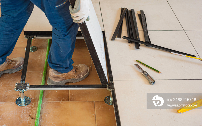 Worker working Raised floor in modern interior of server room in datacenter.