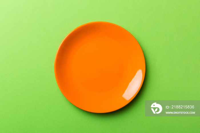 Top view of isolated of colored background empty round orange plate for food. Empty dish with space for your design