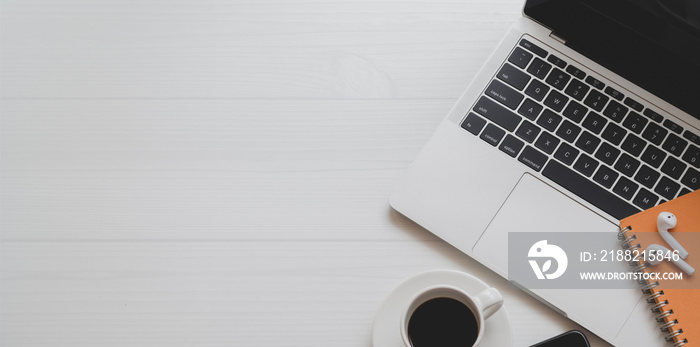 Top view of minimal workplace with laptop computer, coffee cup and office supplies