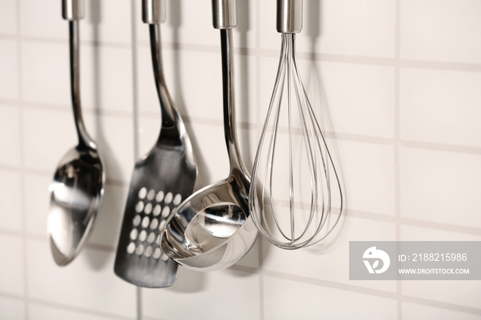 Set of metal kitchen utensils hanging on  wall