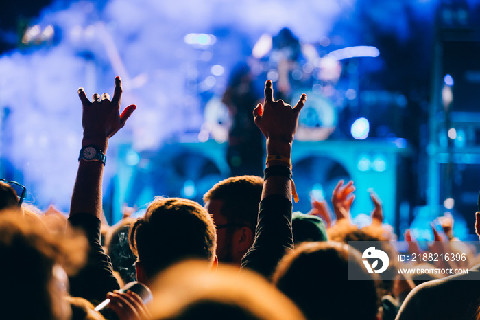 Concert and music festival background with hands raised and party people.