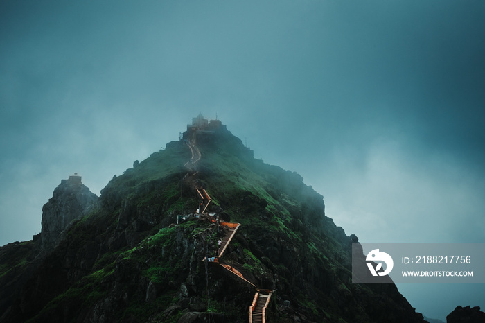 Beautiful view of clouds and fog on top of Girnar hills during monsoon. View of the Dattatreya temple located on the last 10,000th step at Mount Girnar in Junagadh, Gujarat, India