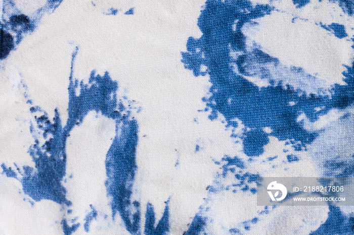 Tie-dye cotton fabric texture blue and white paint colors. Ancient resist-dyeing textile coloring technique, saturated primary colors, bold patterns, simple motifs, monochromatic color schemes garment