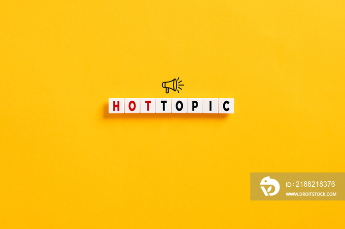 White letter blocks on yellow background with the word hot topic and a megaphone symbol. Popular topics and latest discussion trends.