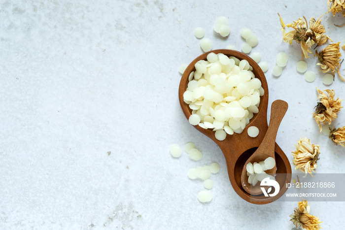 white natural beeswax pellets in wooden bowl for homemade natural beauty and D.I.Y. project.