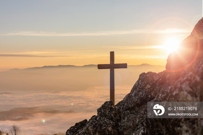 Silhouettes of crucifix symbol on top mountain with bright sunbeam on the colorful sky background