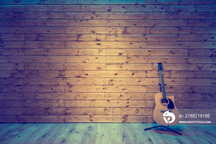 Acoustic guitar on wooden wall, music studio concept background