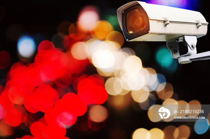 CCTV, security camera system operating with abstract night light bokeh, blurred view of street traffic light in the city at night, surveillance security technology concept, color tone effect
