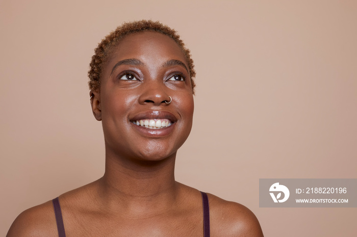 Studio portrait of smiling woman with nose ring