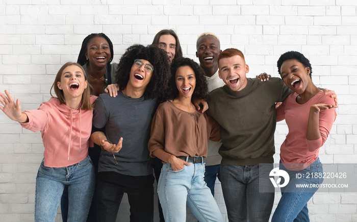 Emotional multiracial friends millennials posing together on white