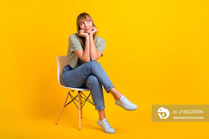 Portrait of lovely minded cheery girl sitting in office chair thinking making decision isolated over bright yellow color background