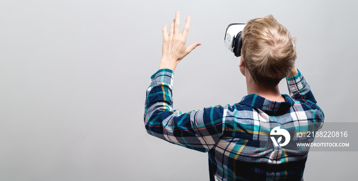 Young man using a virtual reality headset from behind