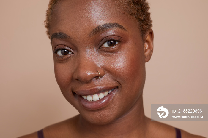 Studio portrait of smiling woman with nose ring