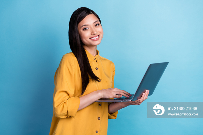 Photo of cute millennial brunette lady type laptop wear yellow shirt isolated on blue color background