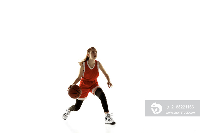 Young caucasian female basketball player in action, motion in run isolated on white background. Redhair sportive girl. Concept of sport, movement, energy and dynamic, healthy lifestyle. Training.