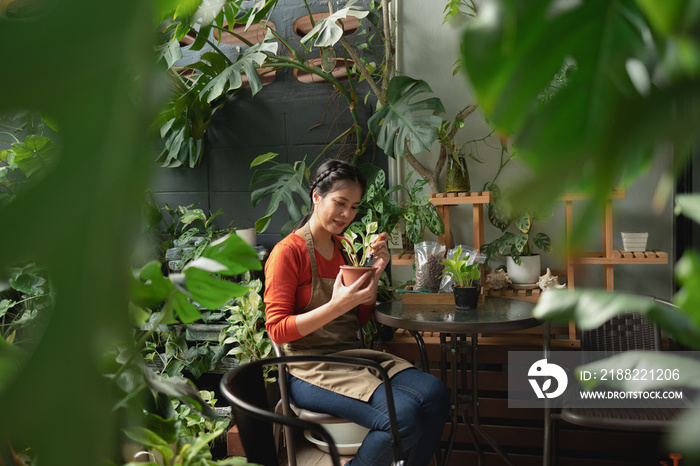 Portrait of smiling Asian young woman Gardener working in houseplant