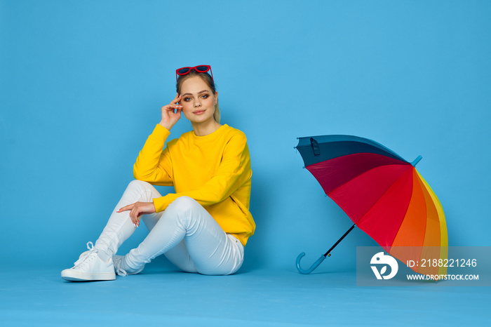 woman with multicolored umbrella in yellow sweater posing rainbow colors