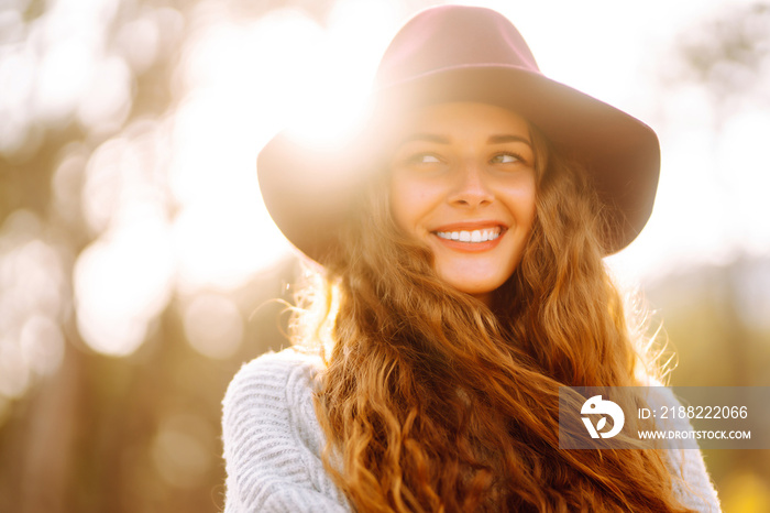 Stylish woman in sweater and hat enjoys autumn nature. People, freedom, lifestyle, travel and vacations concept.