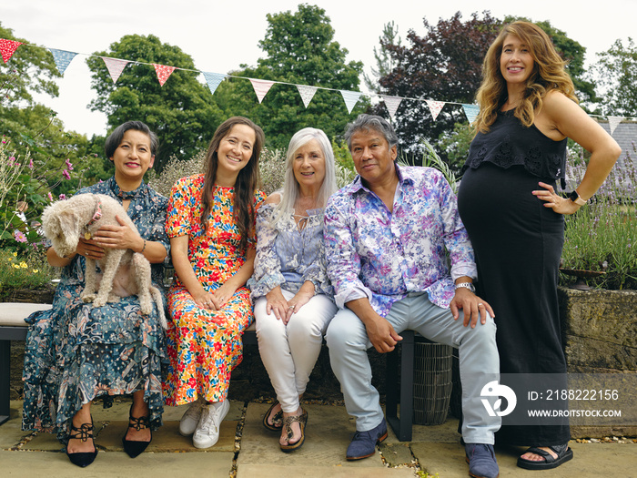 Portrait of family sitting on bench with dog