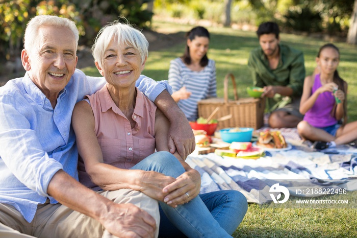 Portrait of happy senior couple sitting in the park