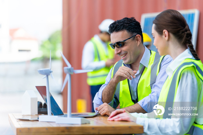 factory engineer Male and Female Industrial meeting and Discuss project with laptop. Worker people checking model machine of wind turbine for clean energy. New technology renewable energy industrial.