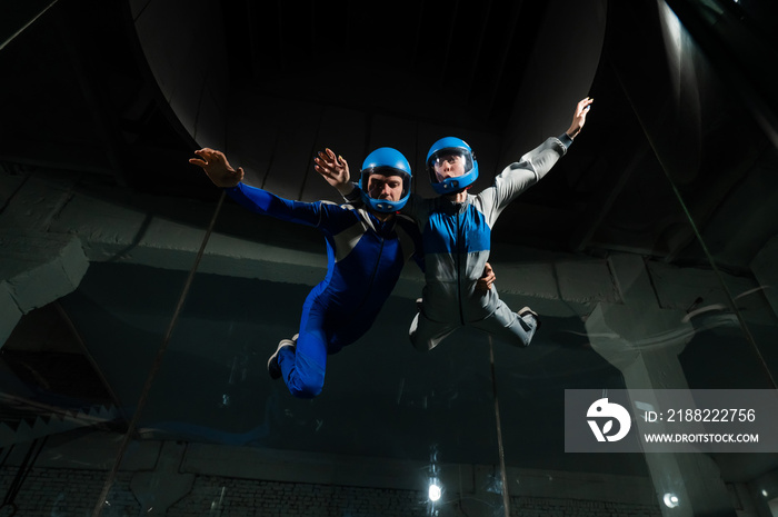 A man and a woman enjoy flying together in a wind tunnel. Free fall simulator