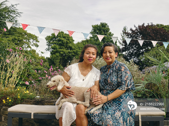 Portrait of smiling sisters holding dog