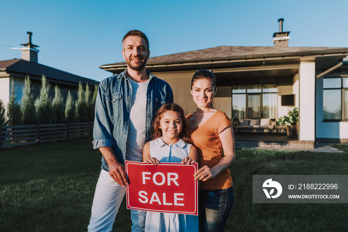 Positive young family standing on the backyard