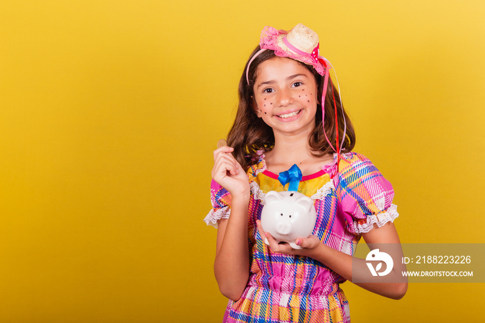 Brazilian, Caucasian child, Festa Junina clothes, close-up photo, finances, holding piggy bank, money, savings, currency. May, June and July festivities, festa junina celebrations