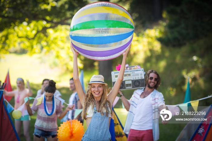 Woman holding beach ball at campsite