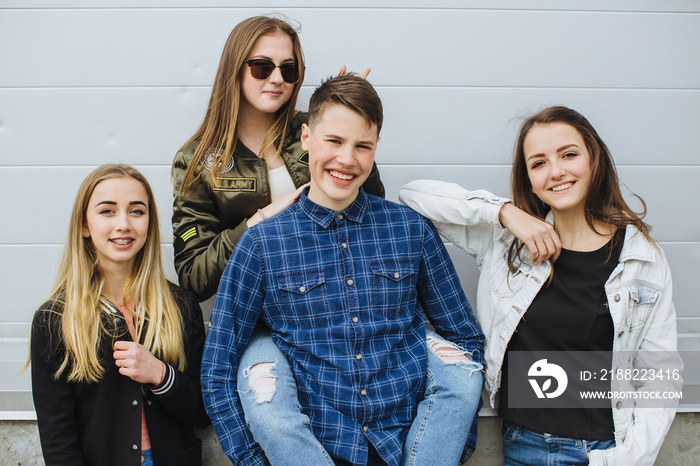 Summer holidays and teenage concept - group of smiling teenagers with skateboard hanging out outside.