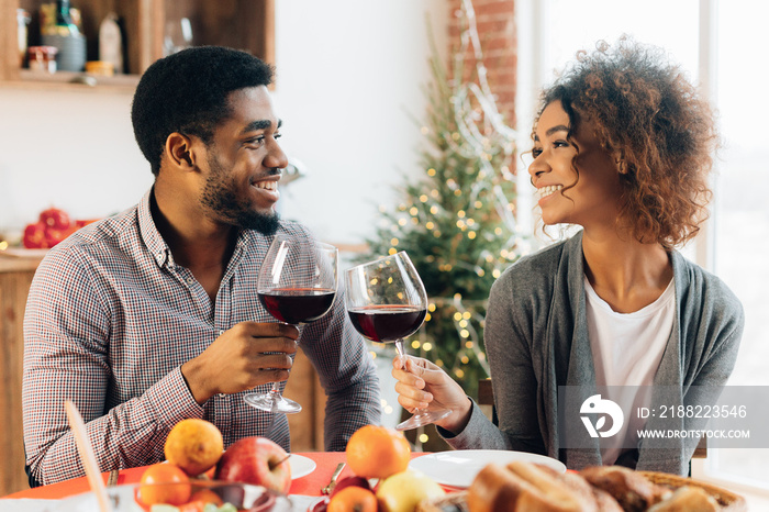 Happy couple celebrating and cheering with glasses of wine