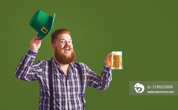 Happy St. Patrick’s Day. Fat man in a green hat holds his hands up glasses with beer