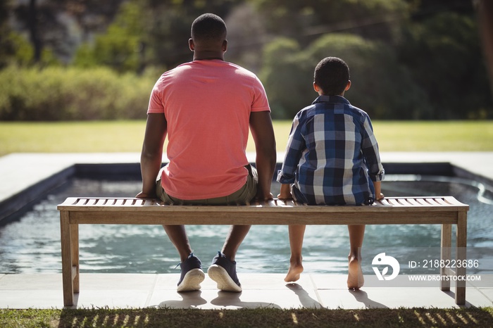 Father and son sitting together on bench