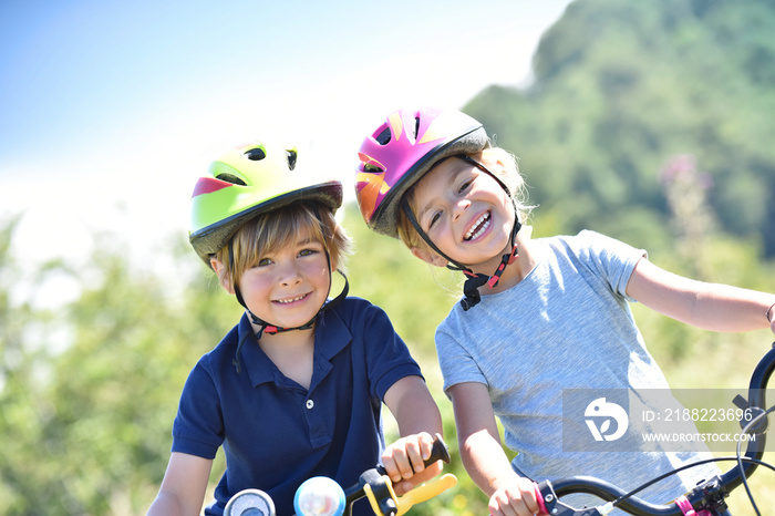 Portrait of cheerful kids riding bikes