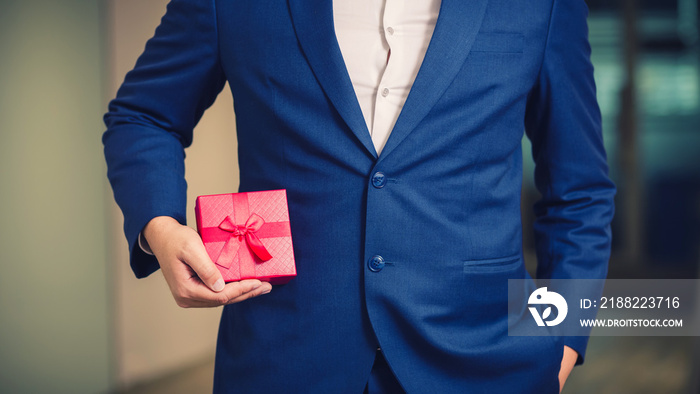 Businessman holding the red gift box