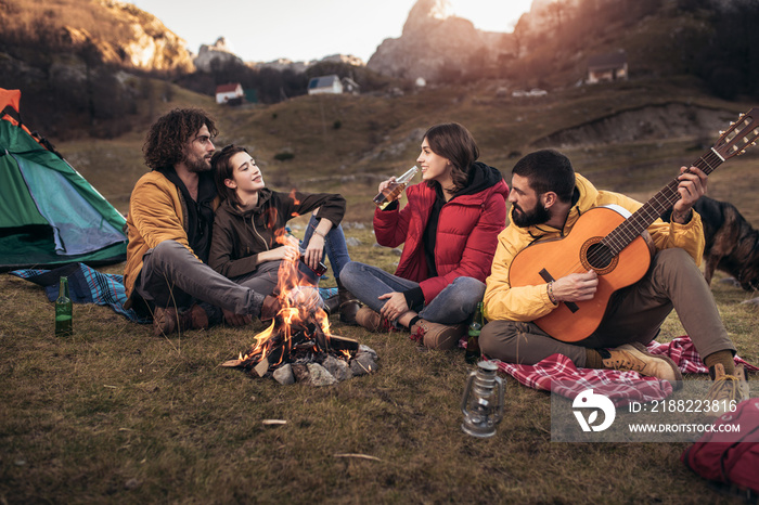 Group of young people around camp fire.