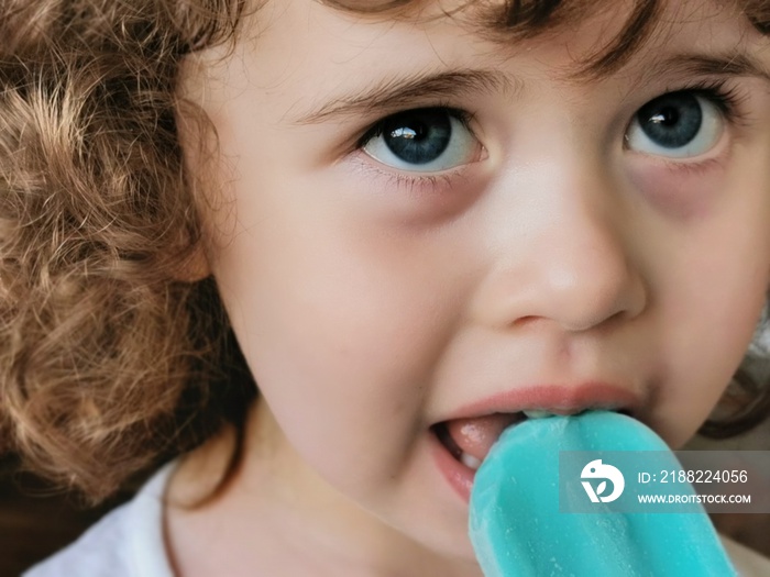 Little girl enjoying her blue Popsicle