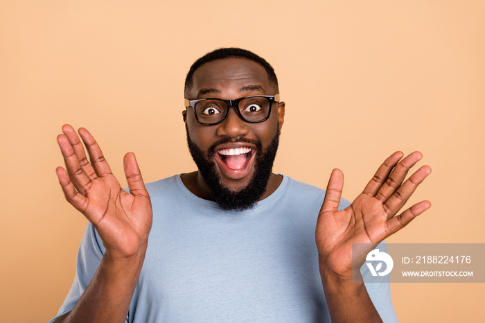 Photo of cool young brunet guy look camera wear spectacles blue outfit isolated on beige color background