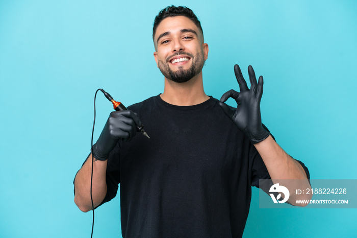 Tattooist Arab man isolated on blue background showing ok sign with fingers