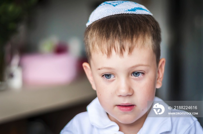 A beautiful blue eyed Caucasian kid with a traditional Jewish kippah cap on his head. A Russian-speaking Jew in Israel portrait. Post-Soviet Jews make up over 15 per cent of Israeli society.