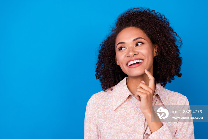 Portrait of pretty positive girl finger touch chin beaming smile look empty space isolated on blue color background