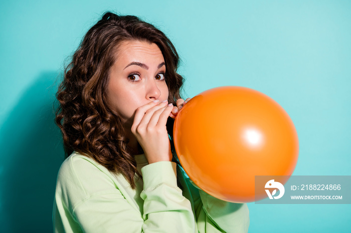 Profile photo of lovely young funny lady inflate orange balloon empty space wear green sweater isolated blue color background