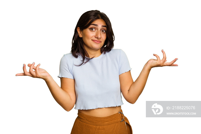 Young Indian woman isolated on green chroma background doubting and shrugging shoulders in questioning gesture.