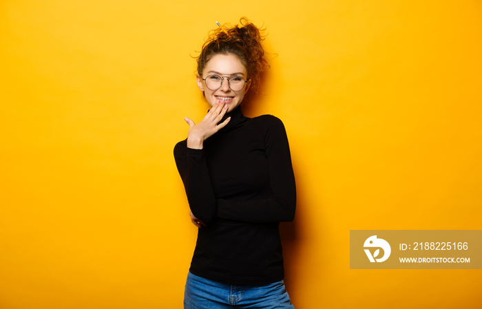 Pretty teenage girl with happy face on yellow background